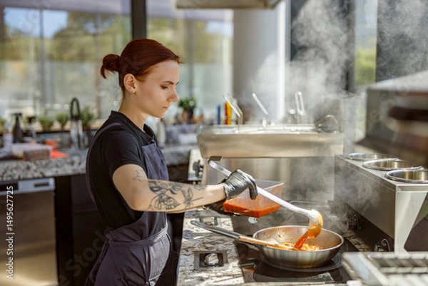Obraz A highly skilled chef gracefully stirs a steaming pot full of flavorful and aromatic sauce in a modern kitchen