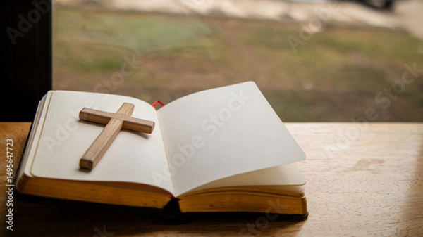 Fototapeta Cross and Bible placed on the table by the window symbolizing faith and devotion to God, preparing to learn God's teachings from the Bible.Concept of praying for blessings from God with faith.