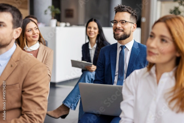 Fototapeta Portrait of businessman sitting in auditorium with laptop during seminar and following lecture.