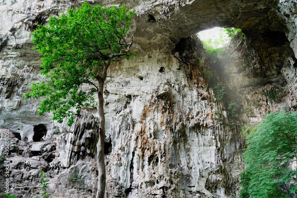 Obraz Light shines through the hole of the cave at Tham Than Lot Yai, Chaloem Rattanakosin National Park, Kanchanaburi Province,Thailand.