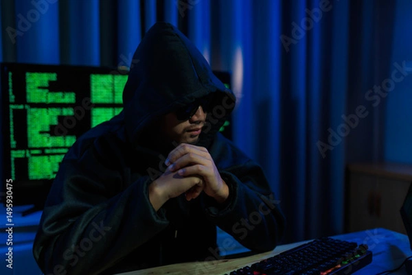 Fototapeta Male hacker in a dark room trying to steal global user data to sell on the dark web, representing serious threats in modern cybercrime.