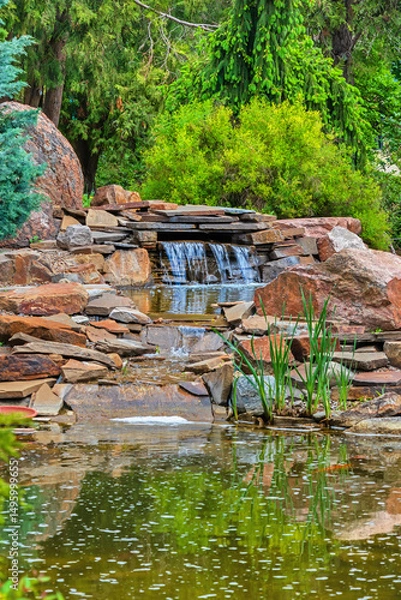 Obraz Small waterfall and stream near decorative pond. Garden design with stones