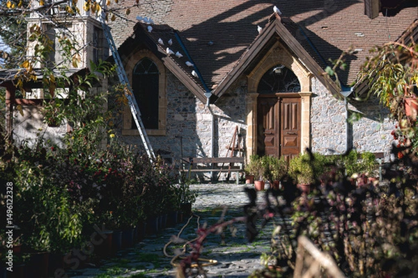 Obraz Doves resting on the tiled roof of a traditional stone church in Platanistasa, a picturesque village nestled in the Troodos