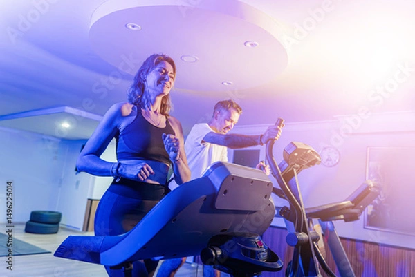 Fototapeta Couple working out in home gym, Personal trainer assisting client