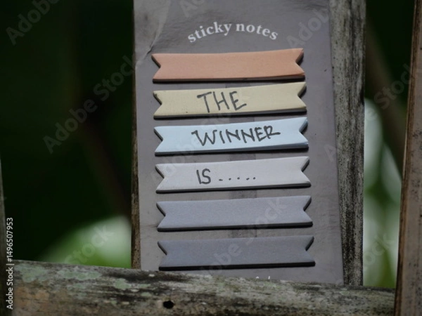 Fototapeta The phrase "The Winner Is" announces success, highlighting victory, celebration, and outstanding achievement proudly.