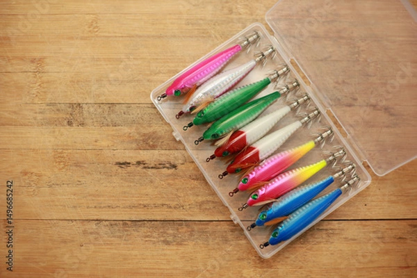 Fototapeta Squid bait is in a plastic box on a wooden floor with space for copying.