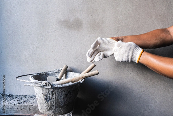 Fototapeta Construction worker preparing tools construction site action shot indoor environment close-up view craftsmanship focus