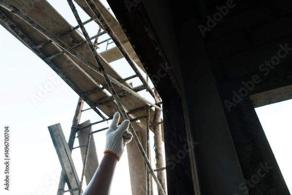 Fototapeta Construction worker inspecting framework urban site action shot daylight close up safety and precision in building
