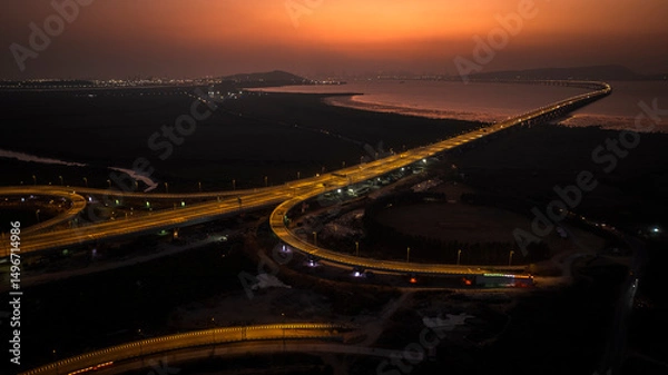 Fototapeta India's longest sea bridge: Trans-Harbour Sea Link. Atal Setu sea bridge in Mumbai, Maharashtra, India. Time-lapse of a city at night with bright skyscrapers and a dense network of glowing buildings.