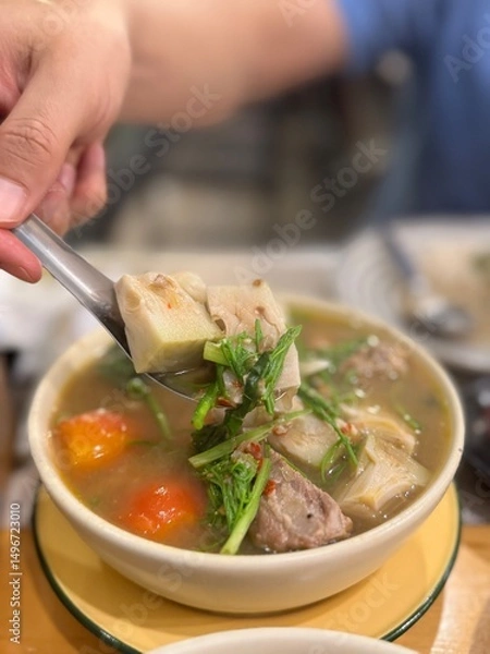 Fototapeta Authentic Northern Thai young jackfruit curry (Gaeng Khanun or Gaeng Ba Nun), a flavorful and aromatic herbal soup with tender jackfruit, pork ribs, and various local vegetables and herbs, being serve