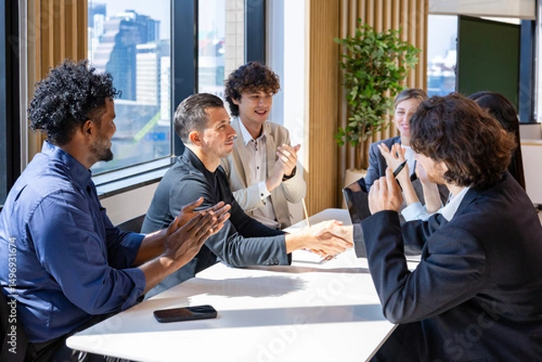 Fototapeta Team of diversity business people having agreement and handshake deal over new strategic strategy project on investment real estate with recognition and applause from other colleagues for partnership