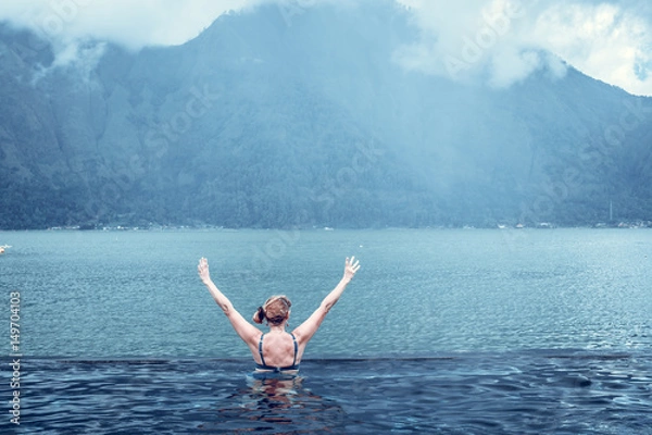 Obraz Senior woman in the nature swimming pool with amazing mountain background. Tropical island Bali, Indonesia.
