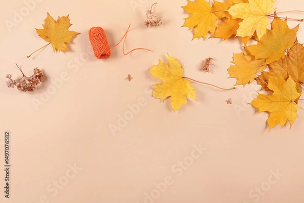 Fototapeta Autumn composition from yellow dried leaves on beige background. Fall background, top view with copy space