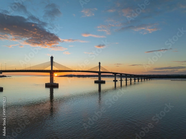 Fototapeta Cua Hoi bridge at sunset over the calm waters of Vinh city in Nghe An, Vietnam showcasing stunning architecture