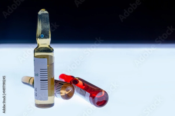 Fototapeta Medical ampoules for injection isolated on a white background. Transparent glass vials with clear liquid used for treatment and vaccination. Sterile pharmaceutical containers in a clinical setting.
