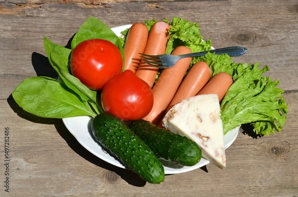Fototapeta A plate of sausages and suluguni cheese with added vegetables and spices.