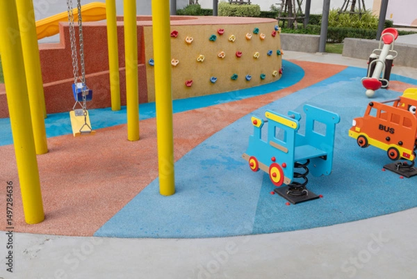 Fototapeta Colorful Playground Equipment with Climbing Wall and Spring Riders for Kids Play Area
