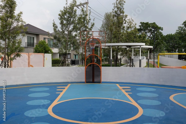 Fototapeta Colorful Outdoor Basketball Court with Unique Design and Surrounding Greenery