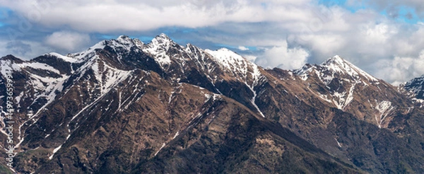 Fototapeta Sweeping panorama showcasing the rugged alpine beauty of Pizzo Alto, Monte Rotondo, and their surrounding peaks under a dynamic cloudy sky in the Lombardy Prealps, Italy