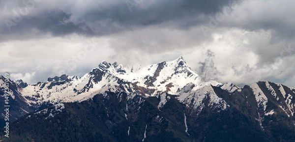 Fototapeta Sweeping panorama of the snow-dusted Pizzo dei Tre Signori mountain range under a vast, cloud-streaked sky, showcasing its jagged peaks and wild alpine beauty. Orobie Alps, Lombardy
