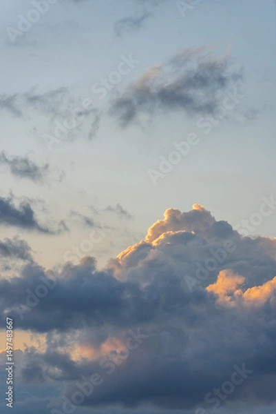 Obraz beautiful gray-blue cumulus clouds with orange tops illuminated by the sun, the mood of summer relaxation and travel