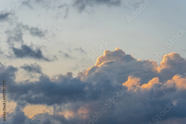 Obraz beautiful gray-blue cumulus clouds with orange tops illuminated by the sun, the mood of summer relaxation and travel