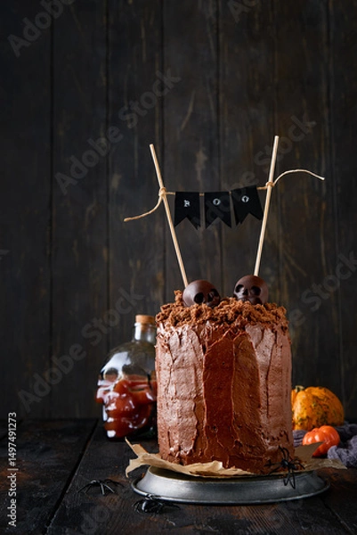 Obraz Spooky and funny chocolate cake layered brownie with earthy crumbs with dark and white chocolate sculls, old bare branches and dry fallen leaves. Sweet funny idea for Halloween party, copy space.