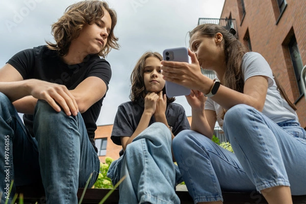 Fototapeta Mom guides her two teen sons on smartphone rules and social network best practices. They discuss online safety, digital citizenship, and healthy tech habits for navigating social media.