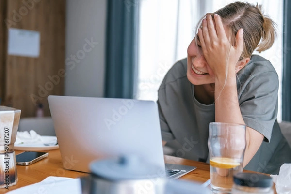 Obraz  Gen Z woman working from home at cozy kitchen table with laptop and phone. Digital nomad lifestyle, mindfulness, remote work, balance, mental calm and modern freelancing