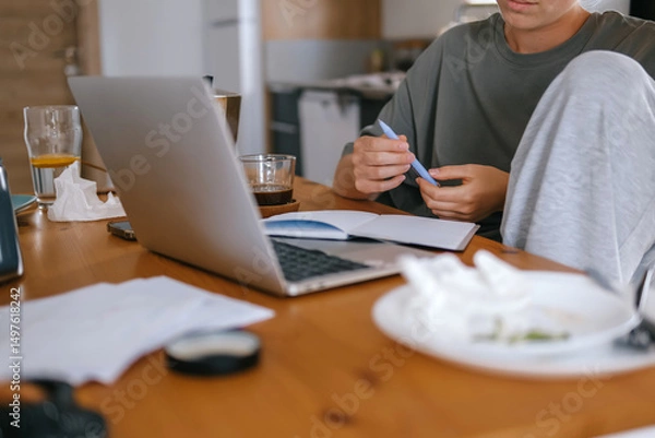 Obraz  Gen Z woman working from home at cozy kitchen table with laptop and phone. Digital nomad lifestyle, mindfulness, remote work, balance, mental calm and modern freelancing