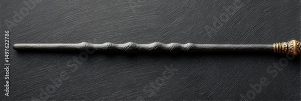 Fototapeta Dark, ornate wand rests on a black surface.  Mysterious and magical.