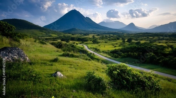 Fototapeta Serene Mountain Landscape: A Winding Road Through Lush Green Fields and Majestic Peaks