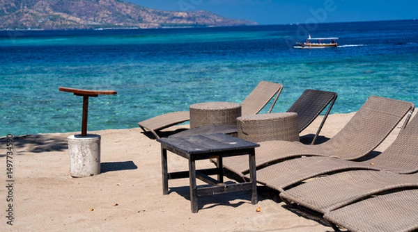Fototapeta Tropical beach with gray lounge chairs for relaxation under the sun
