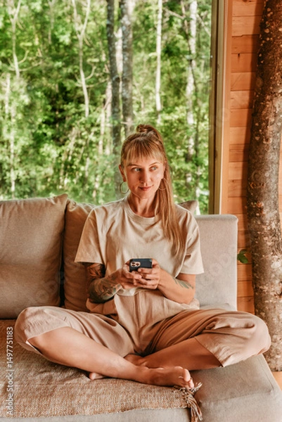 Fototapeta Woman Using Mobile Phone in Log Cabin