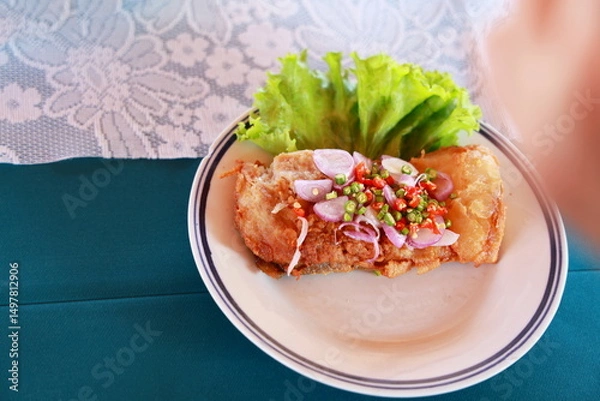 Obraz Sour fish served with spicy salad : Thai Spicy fermented fish with herbs deep-fry until crispy and add sliced ​​shallots, chopped chili peppers, green salad. Squeeze lemon juice. spicy fermented fish.
