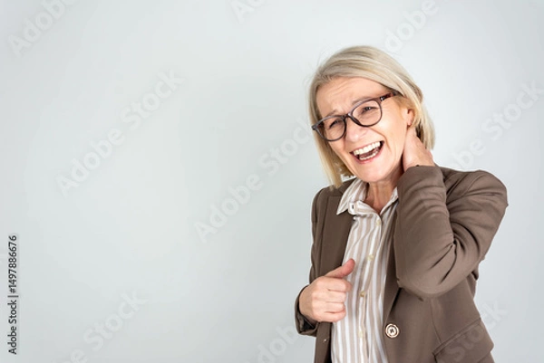 Fototapeta Photo of tired upset mature lady wear business clothes arm neck having pain isolated grey color background