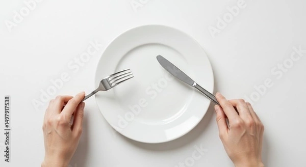 Obraz Empty plate with hands holding fork and knife on white background, top view