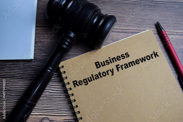 Obraz Concept of Business regulatory framework write on book isolated on Wooden Table.