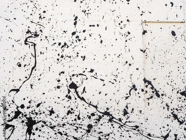 Fototapeta Close-up of white concrete wall texture with abstract black paint splashes. Concept of modern art, street style and urban creativity