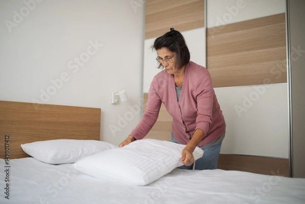 Fototapeta Host prepares the room for her next guest with care