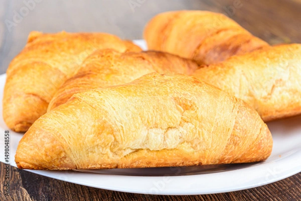 Obraz Selective focus on freshly baked croissants on a white plate.