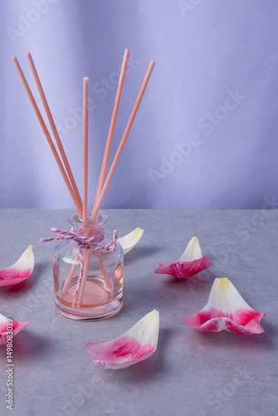 Obraz Fragrant diffuser surrounded by pink petals on a serene surface