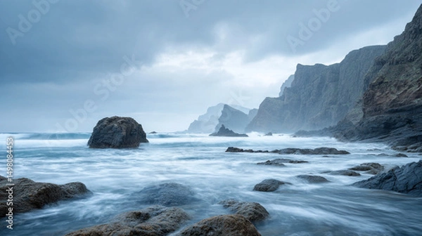 Fototapeta rocky coastline with crashing waves and  cliffs, cloudy sky