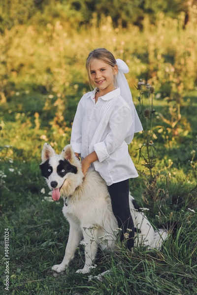 Obraz Smiling blond girl  with her pet dog outdooors on nature in summer. Yakutian Laika dog breed. Happy childhood