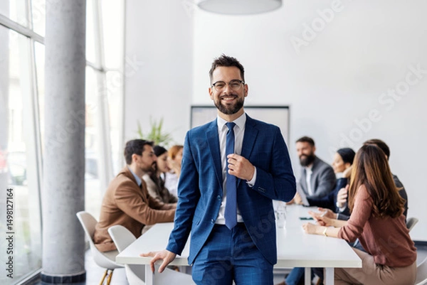 Fototapeta Portrait of manager sitting at conference table with her leadership team and smiling at camera during meeting.