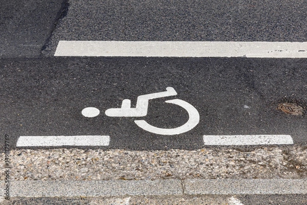 Fototapeta white silhouette of a person sitting in a wheelchair clearly marks parking spaces intended for disabled people.