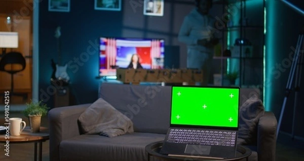 Obraz African american person enjoying music on headset next to copy space screen, feeling happy with remote work and relaxing on the sofa. Relaxed chill guy sitting in his trendy apartment. Camera B.