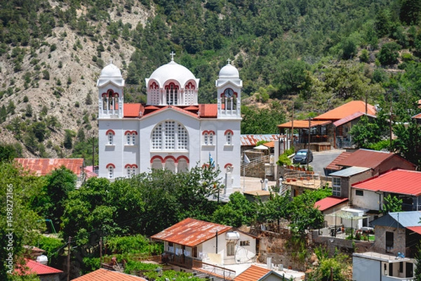 Obraz Timios Stavros Church overlooking Pedoulas village in Cyprus with Troodos Mountains rising in the background