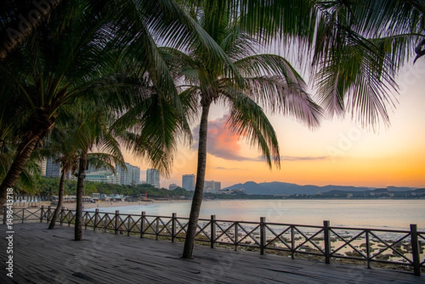 Obraz A palm tree surrounded by small granite rocks on the beach in Sanya, China