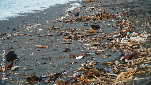 Obraz Garbage is scattered on the beach sand